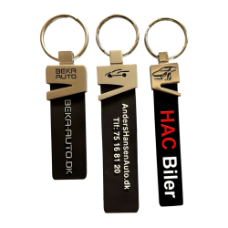 Silicone nglering med metalhovedmed logo/tekst i metallet, mens teksten p er forhjet og farvelagt