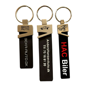 Silicone nglering med metalhovedmed logo/tekst i metallet, mens teksten p er forhjet og farvelagt