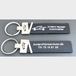 Silicone nglering med metalhovedmed logo/tekst i metallet, mens teksten p er forhjet og farvelagt